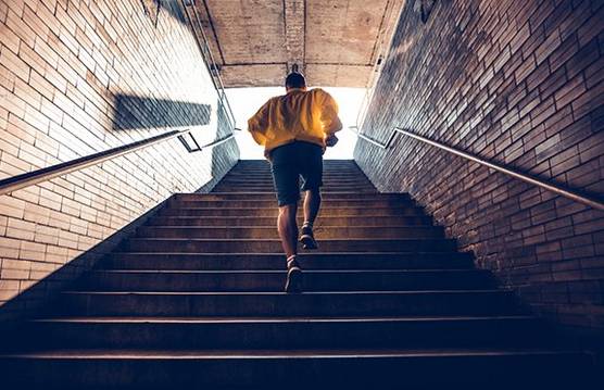 Man running up some stairs, shot from behind