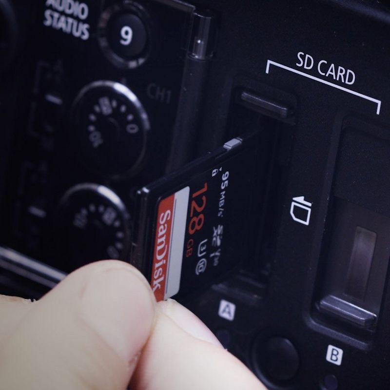 SD card going being slotted into Canon video camera