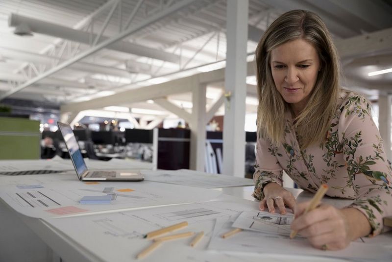 Woman in an office writing on paper