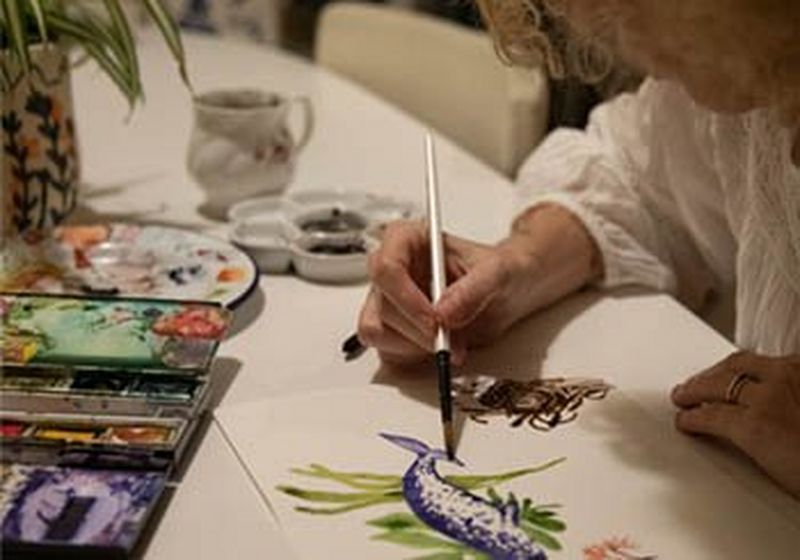 A woman’s hands, painting with watercolours