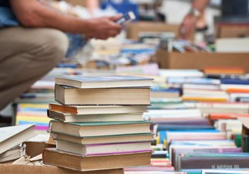 Stacked up books being sold outdoors in a market