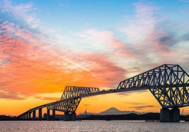 A panorama of the Tokyo Gate Bridge under a beautiful orange sunset