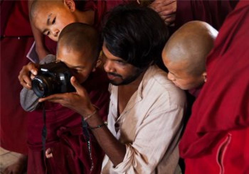 Jérôme Gence shows a group of young monks how to use his DSLR camera to take ID photos for their passports.