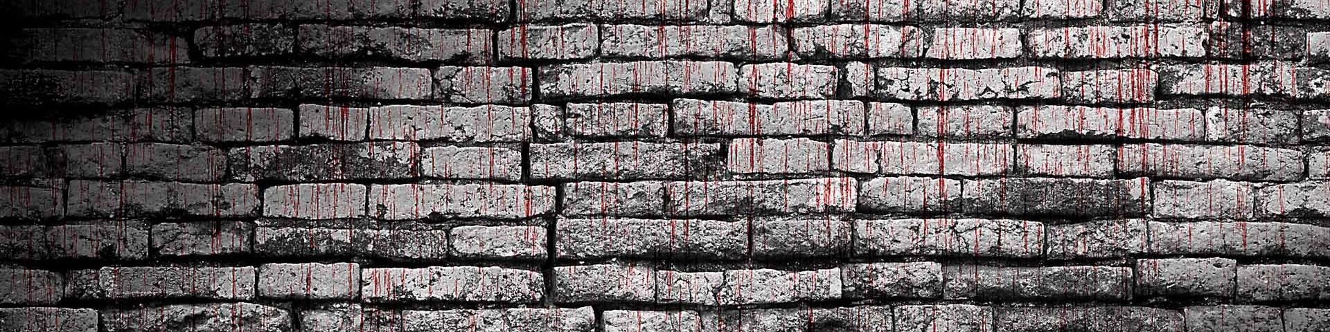 An old grey brick wall, with red blood dripping down it.