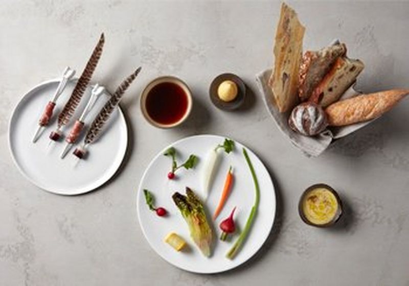 A selection of plates, beautifully arranged. Vegetables, meats and assorted bread.