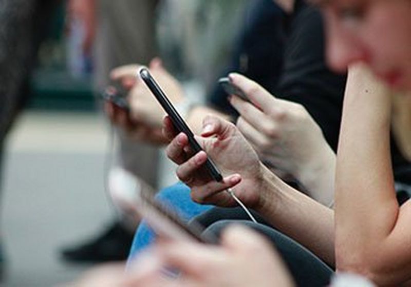 People sat, looking at their smartphones