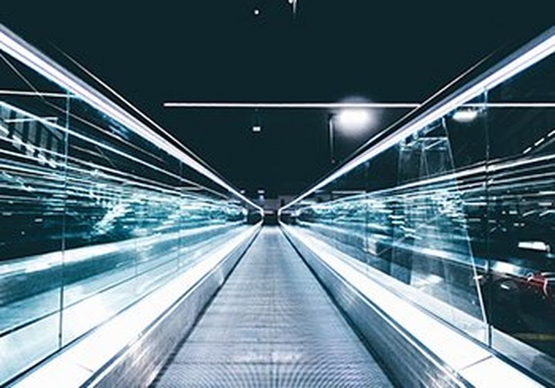 Grey conveyor between glass frames at night