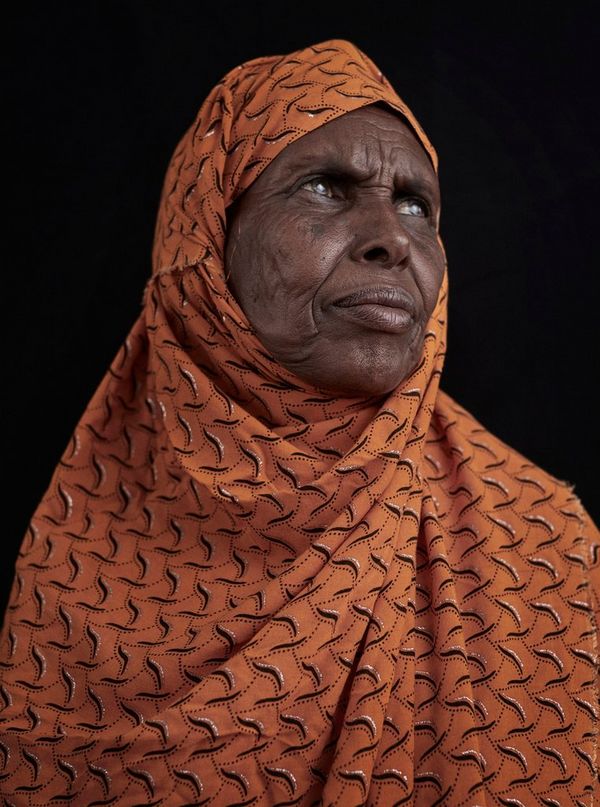 A portrait taken in rural Somaliland of a village elder in an orange patterned headscarf.