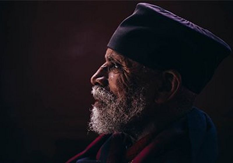 Side head and shoulders view of an Ethiopian monk in robes.