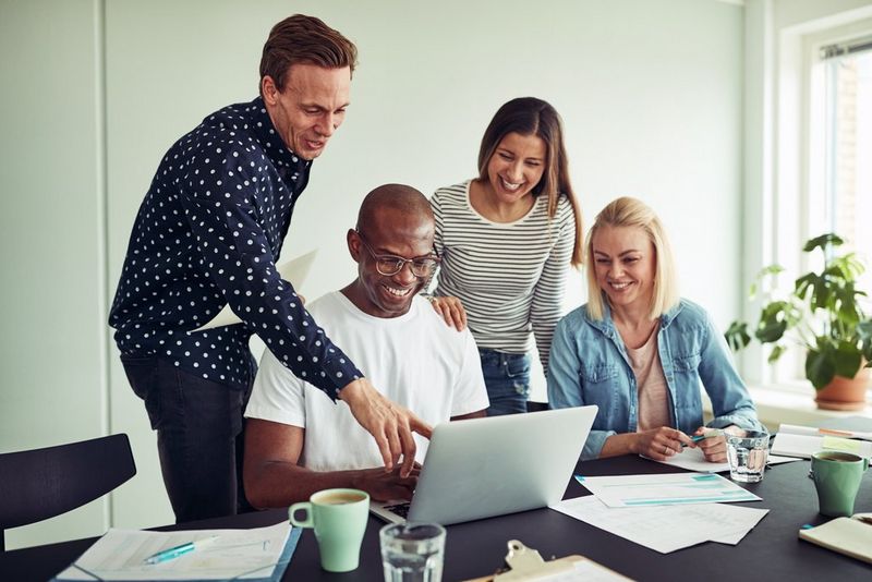 Work professionals looking at a laptop smiling