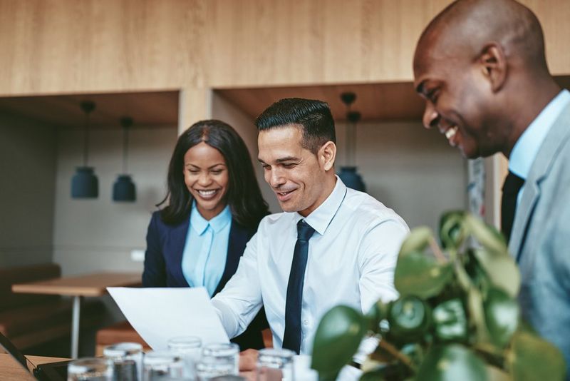 Three work professionals looking at a document