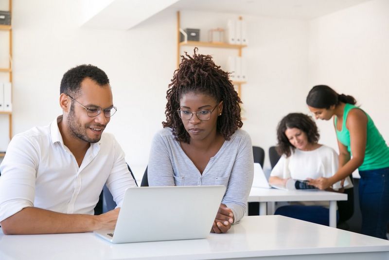 Work professionals sitting together looking at a laptop