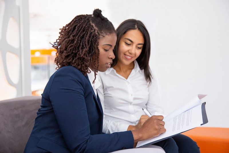 two work professionals looking at a document 