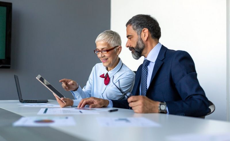 two work professionals looking at a tablet together