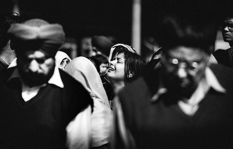 Woman crying at the cremation of her father in India in a sea of men