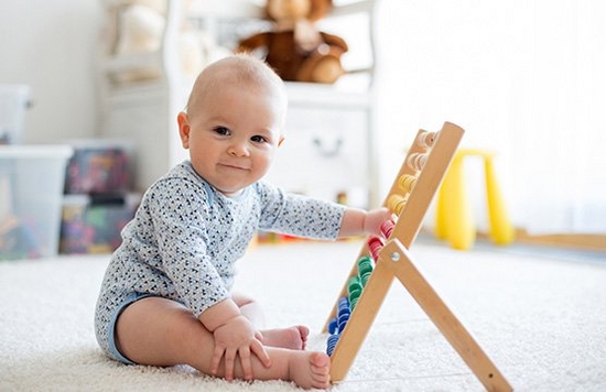A baby playing with an abacus.