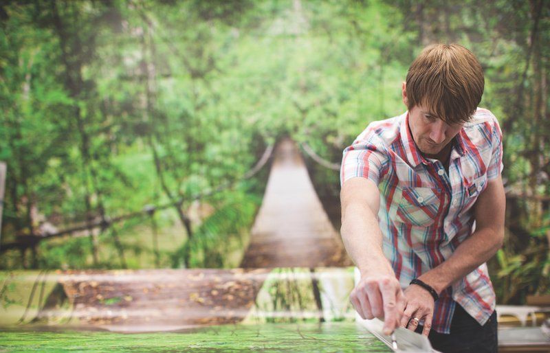 Man in workspace in front of green printer background