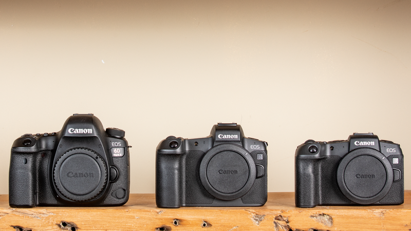 Three Canon cameras on a shelf.