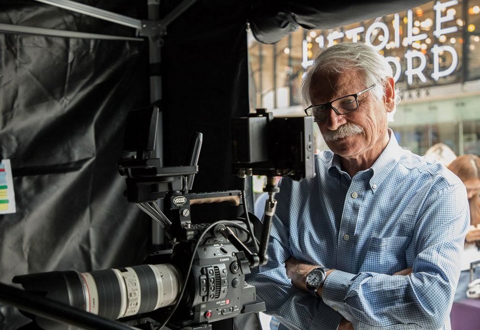 Yann Arthus-Betrand looks at a monitor by a video camera.