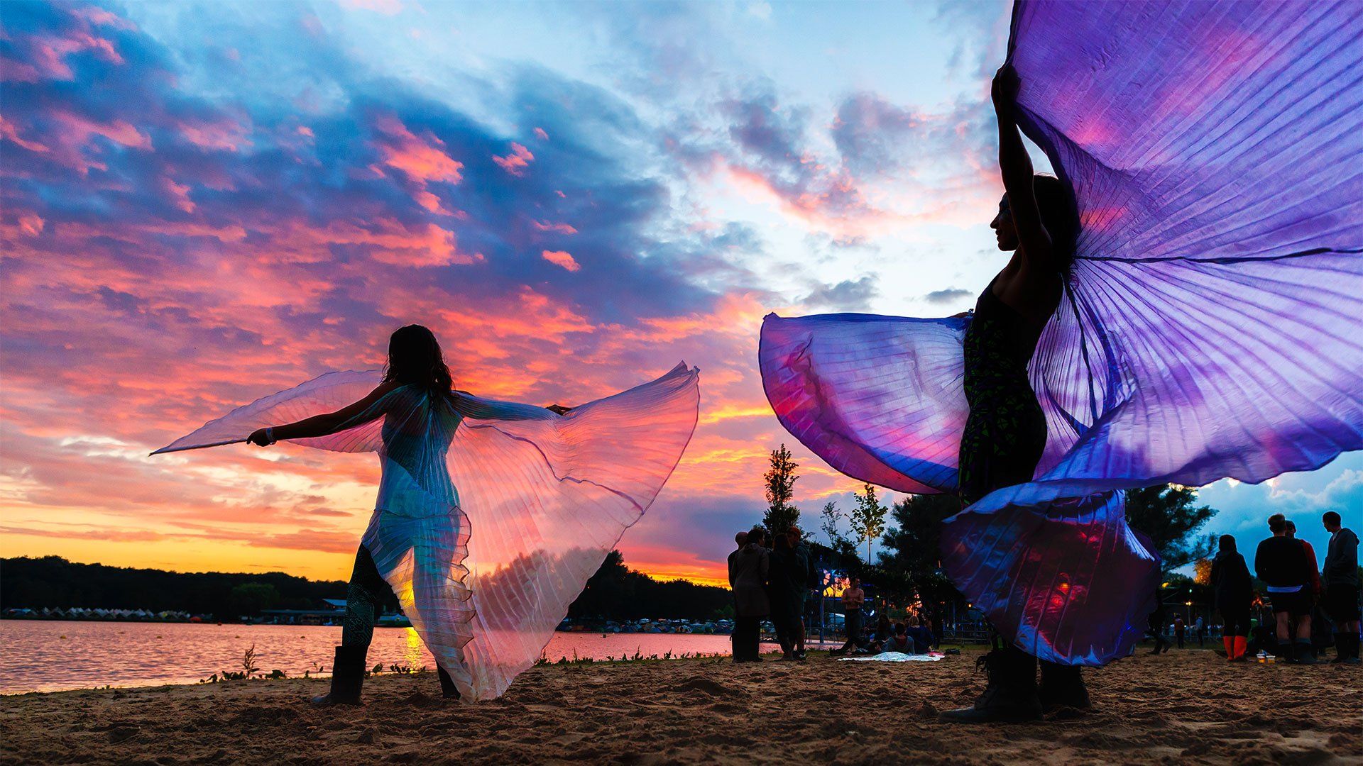 Two women twirl colourful silks at sunset. Photo by Bart Heemskerk.