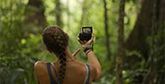 Laura Bingham pictured from behind, facing dense jungle, as she films a vlog with a Canon PowerShot G7 X Mark II.