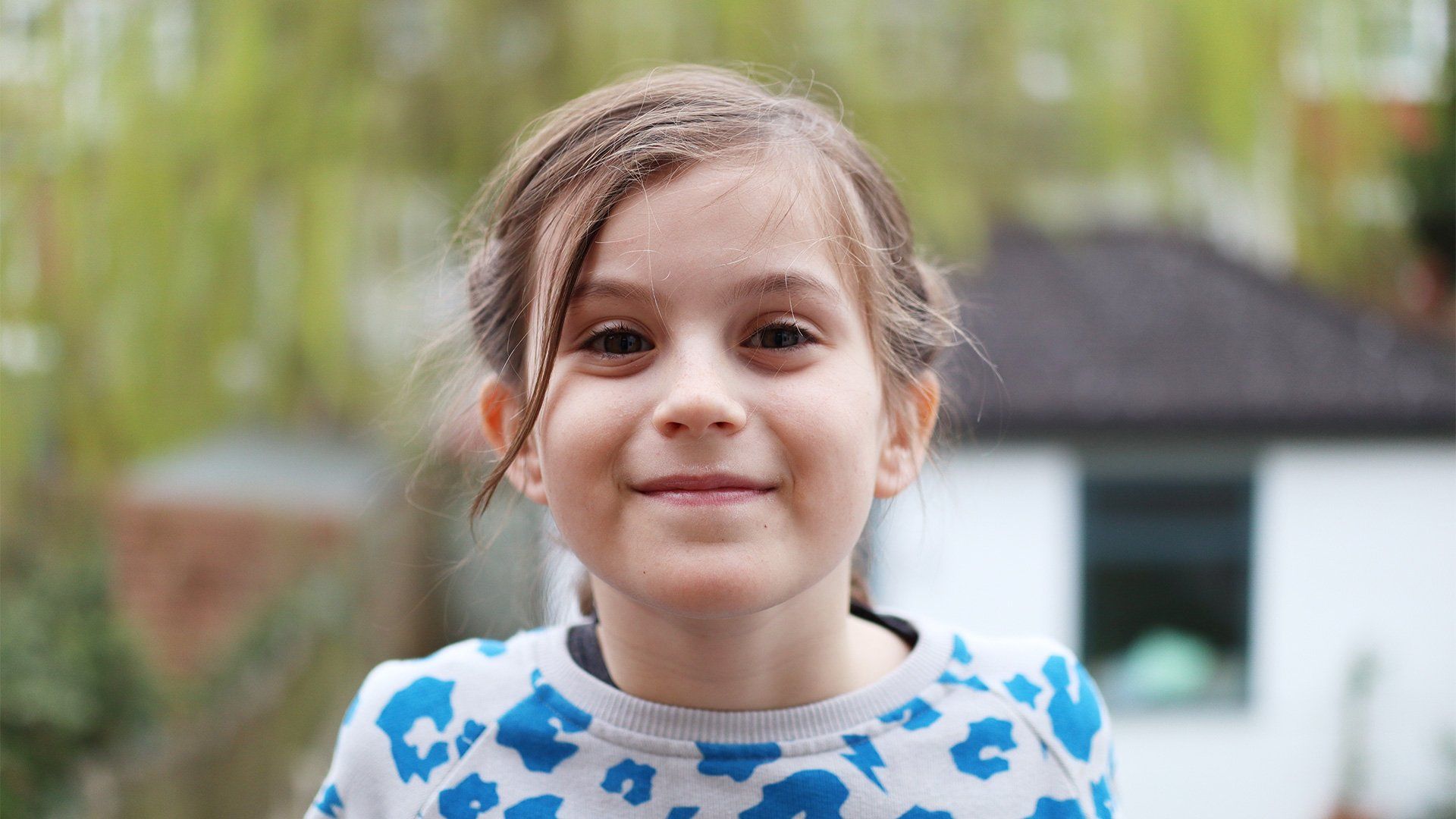 A portrait of a girl smiling, the background blurred. Taken on a Canon EOS M50 by Katja Gaskell.