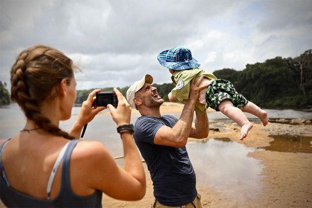 Laura photographs her husband Ed Stafford playing with their son on a beach.