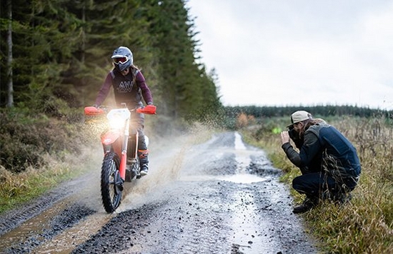 Photographer Tom Bing takes a picture of a dirt bike rider.