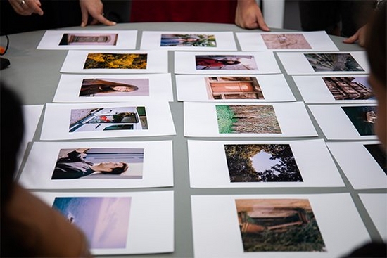 Photos are laid out on a table to be reviewed.