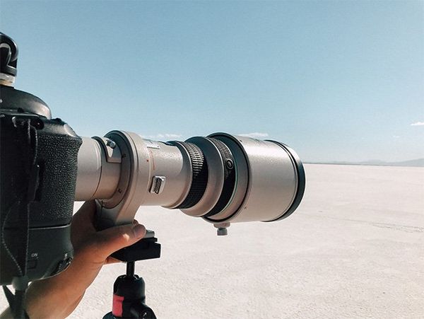 A long Canon lens is pointed out at Utah's salt flats.