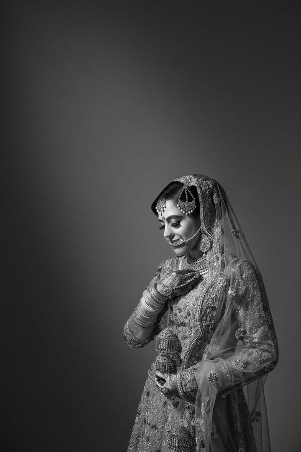 A black-and-white image of a bride adorned in jewellery and henna. Taken by wedding photographer Sanjay Jogia.