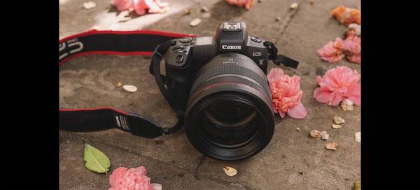 Rosie Hardy’s Canon EOS R with Canon RF 85mm F1.2L USM lens, with flowers beside it.