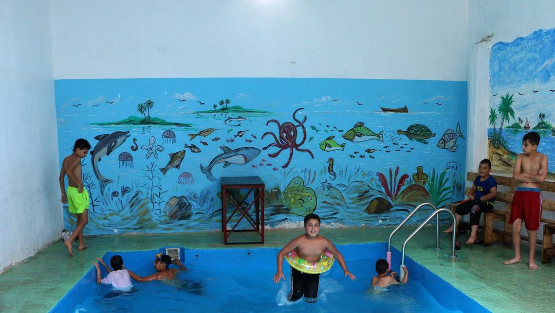 Children play in a swimming pool in a refugee camp in Lebanon, captured by a refugee living in the camp. 