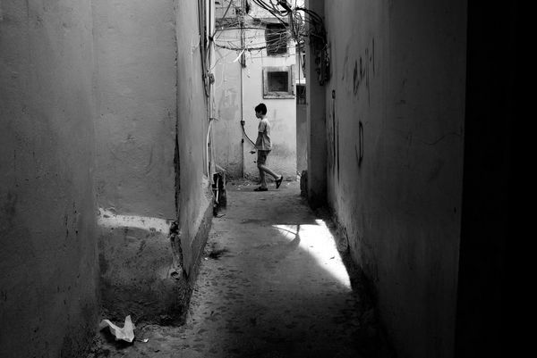 A child playing in an alleyway during summer where it can be dangerous with low-hanging electrical wires. Photographed by a refugee living in the camp in Lebanon. 