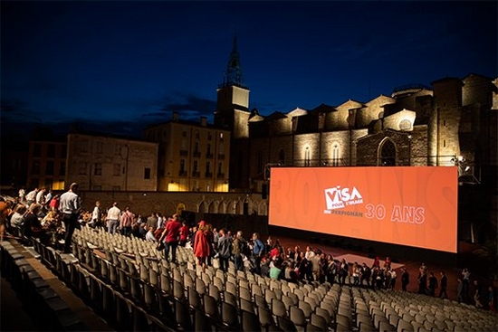 The stands filling with viewers at the outdoor night-time screening at Visa pour l’Image 2018.