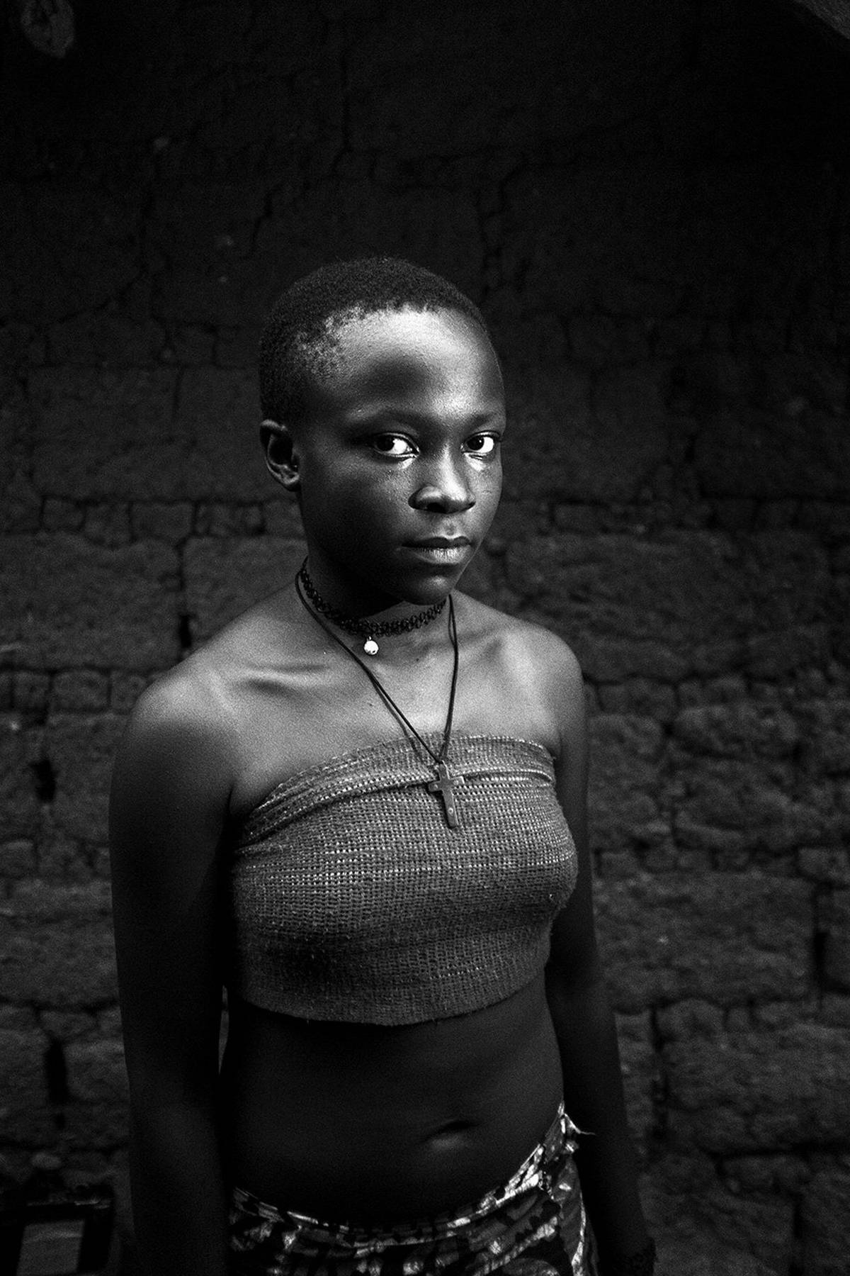 In Cameroon, Wetshibi poses for the camera after having her breasts massaged with a stone. 