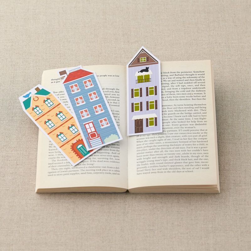 House-shaped bookmarks, created from Canon Creative Park templates, arranged on the open pages of a book.
