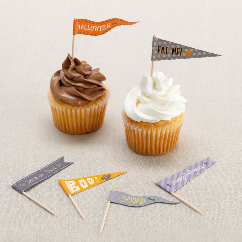 Two iced cupcakes decorated with Halloween-themed cake flags.