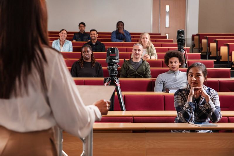 A Canon CR-N100 PTZ camera set up in a lecture theatre filled with students.