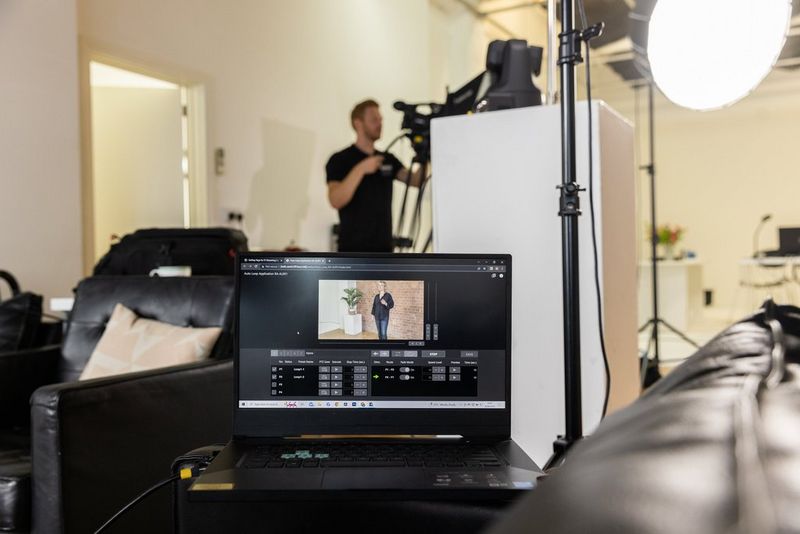  A laptop screen shows the Auto Loop app in use while a man operates a Canon XF605 in the background.