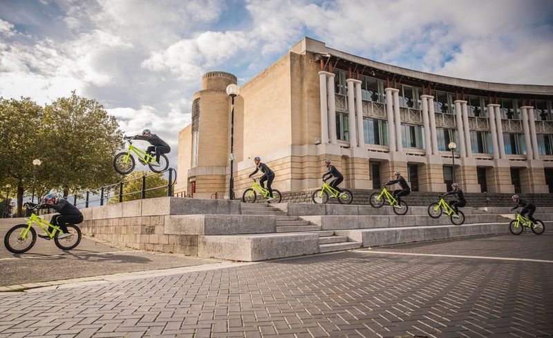 A composite image showing seven images of a cyclist performing a jump over a set of stone steps. 