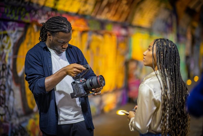 Cinematographer Jolade Olusanya using the touchscreen on a Canon EOS C70 as he films poet Sophia Thakur.