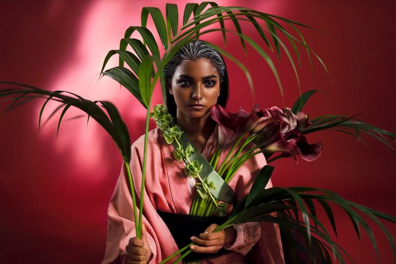 A model stands amid tropical flowers and plants in this portrait taken by Guia Besana with a Canon RF 50mm F1.2L USM lens. 