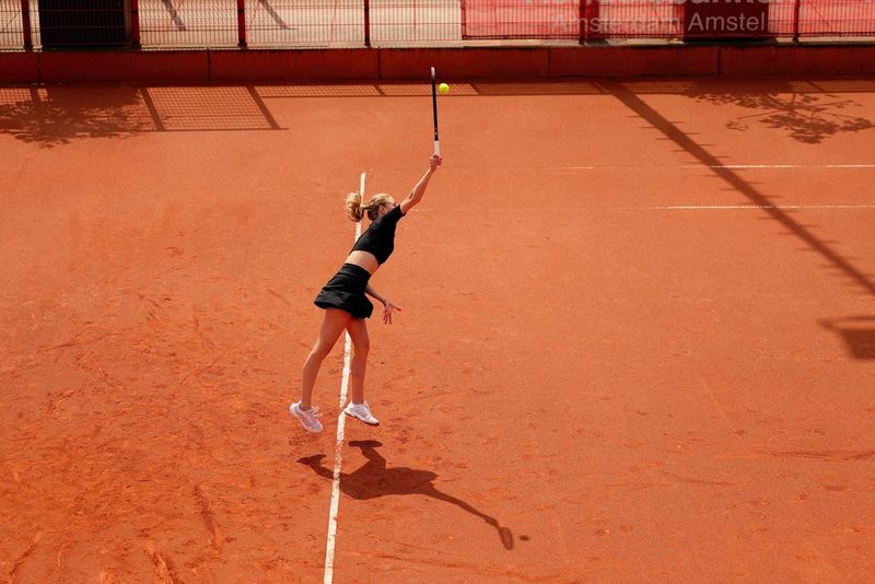 Four basketball players in action on a court, one captured dribbling the ball with the ball in mid-air. Shot on Canon EOS R1.