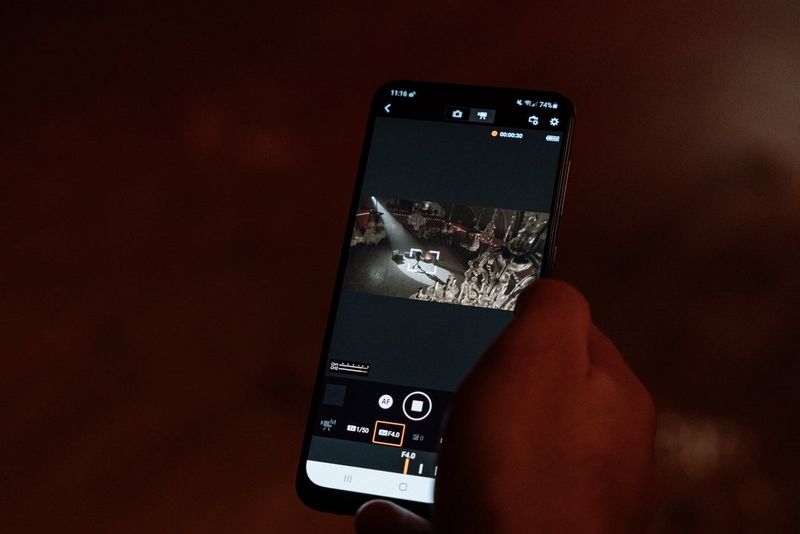  A hand holding a smartphone with video footage on the screen. 