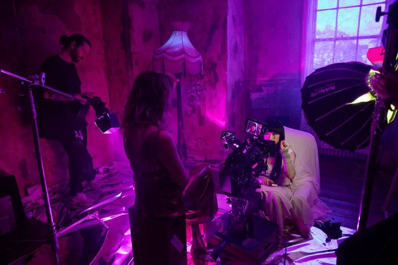 Filmmaker Diana Olifirova stands over a Canon cine camera, recording a person's face in close-up.