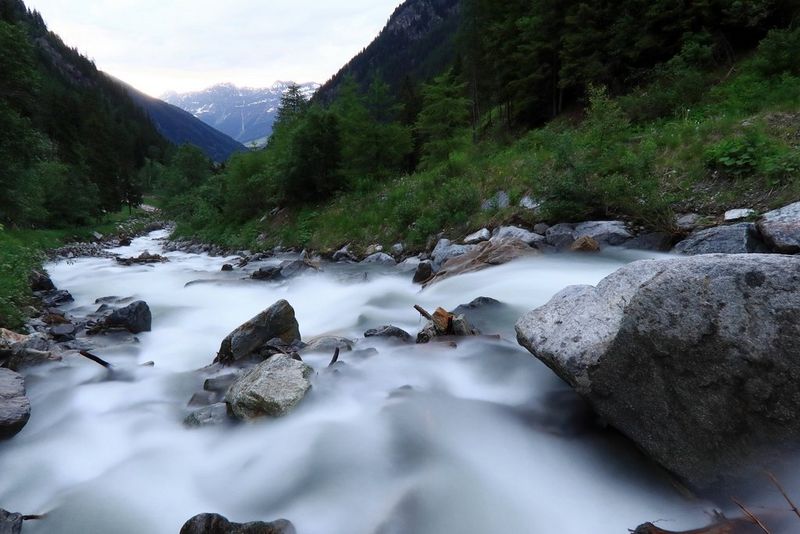 A long-exposure photo of a river in a steep valley, taken on a Canon PowerShot G5 X Mark II. The long exposure has made the flowing water look like a milky blur, while the rest of the scene is sharp. 