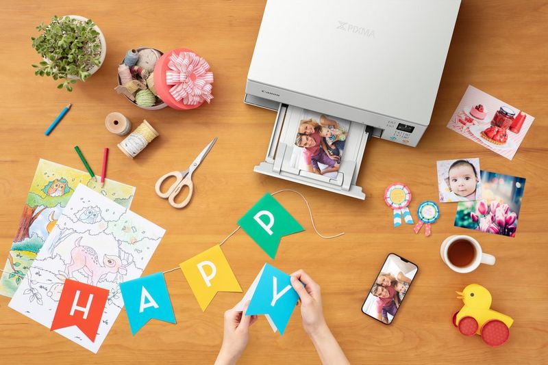 A Canon PIXMA TS6350 printer on a table top, printing out images for birthday decorations.