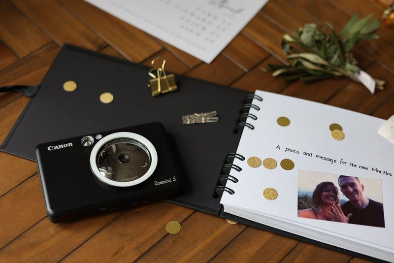 A black Canon Zoemini S on top of a guestbook at a wedding. 