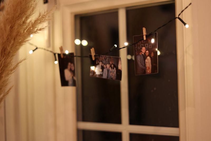 Canon Zoemini prints hung on a string of fairy lights in front of a window. 